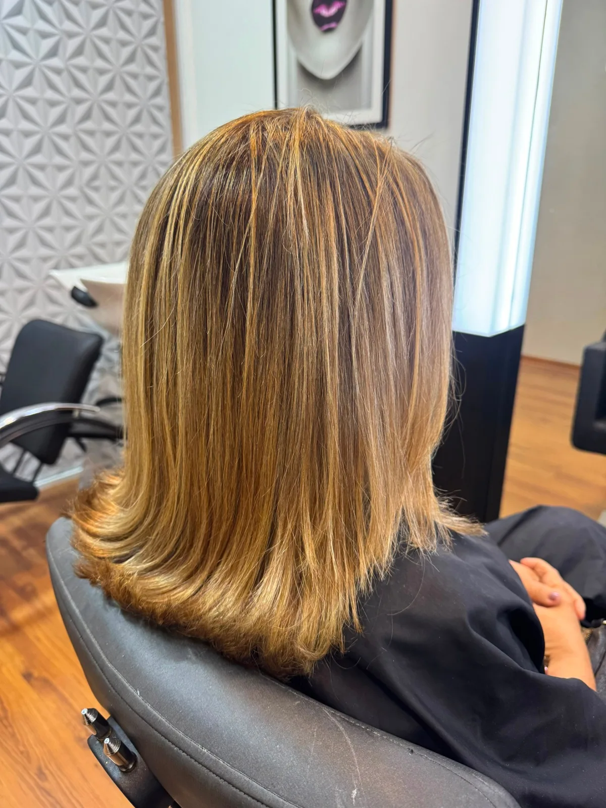 Cabelo alisado com acabamento liso e alinhado visto por trás no salão